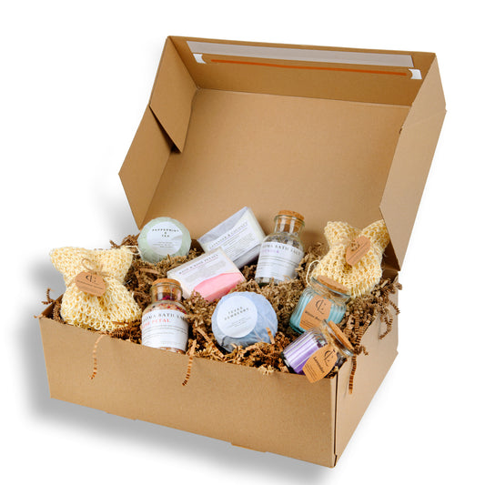 Box of bath products including soaps and bath bombs on a white background