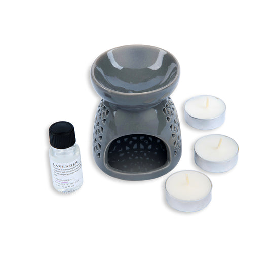 Gray essential oil diffuser with three candles and a bottle of lavender oil on a white background