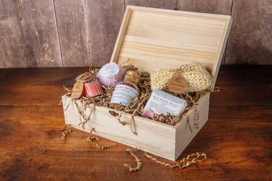 Wooden gift box with bath products on a wooden surface