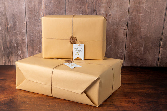 Two packages wrapped in brown paper with a wooden background