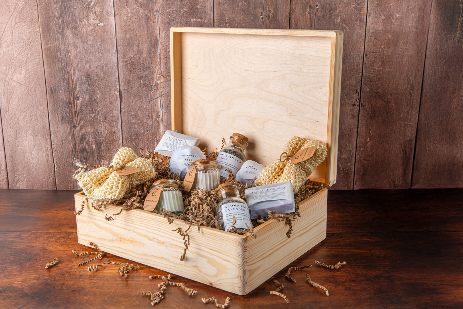 Wooden box with bath products including loofahs and soap bars on a wooden background