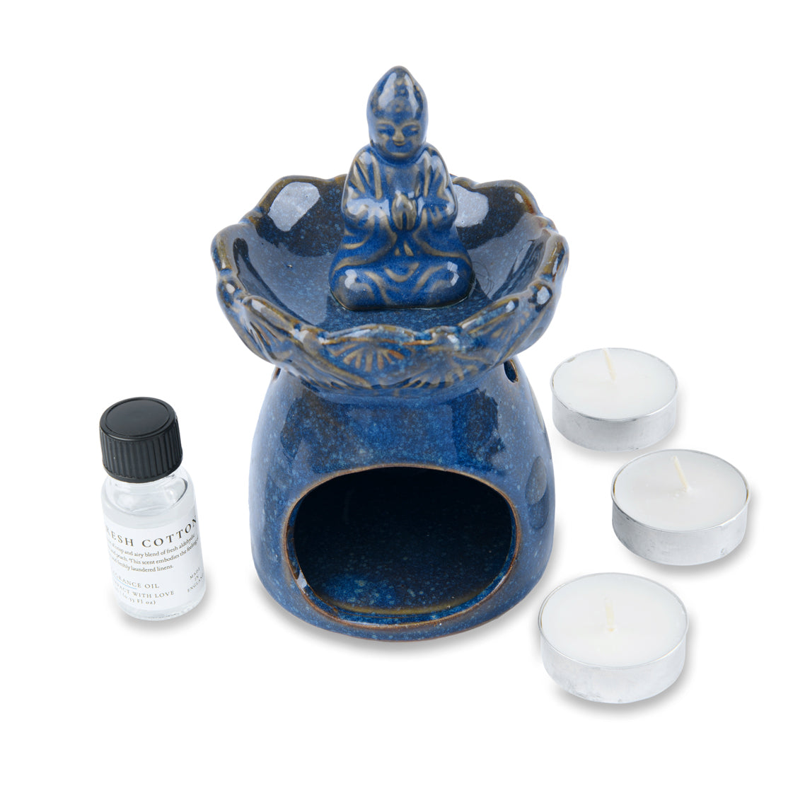 Blue ceramic oil burner with Buddha figure, essential oil bottle, and tea light candles on a white background