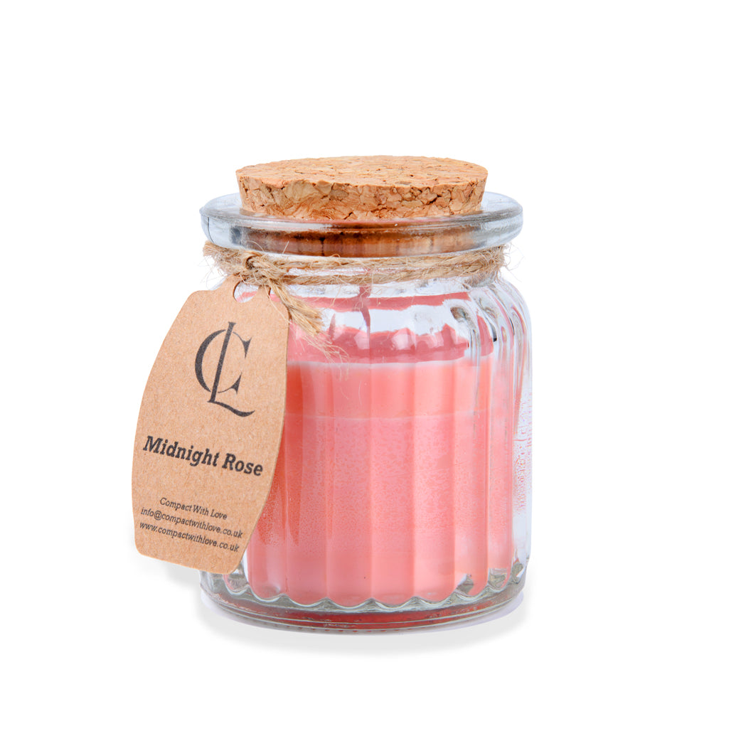 Glass jar with pink candles and cork lid on a white background