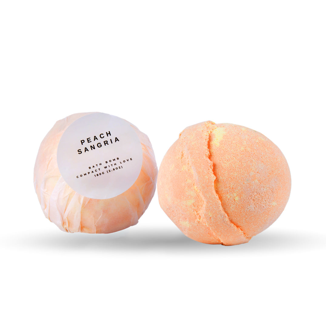 Two peach-colored bath bombs with a label on a white background