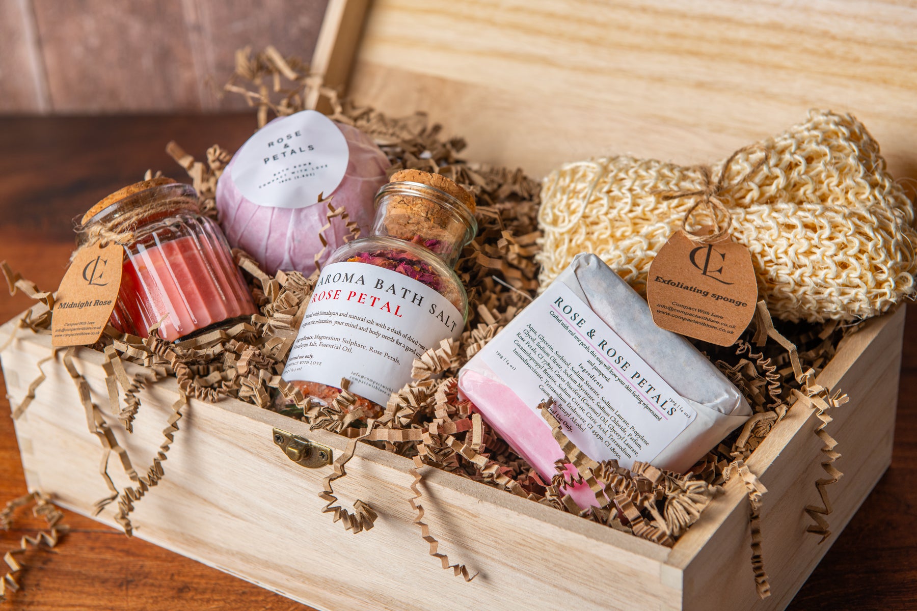 Bath and body products including soap, bath salts, and a loofah in a wooden box.