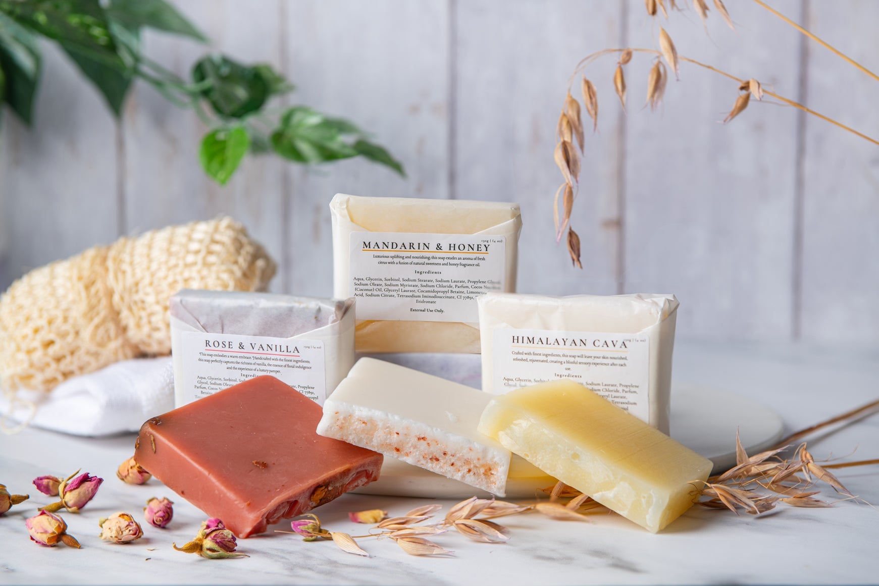 Various soaps with visible branding on a light wooden surface with decorative elements.