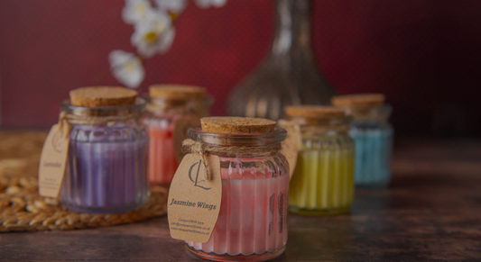 Jars of candles with visible labels on a wooden surface